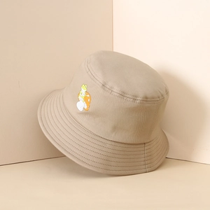 Detail of khaki bucket hat showing fine embroidery of a frog playing guitar and mushrooms