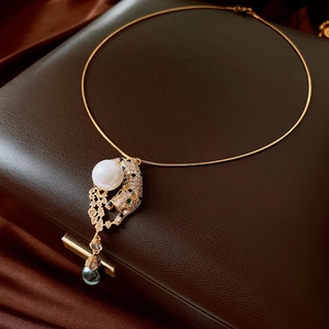 Macro shot of gold leopard pendant with sparkling zircons and elegant white pearls