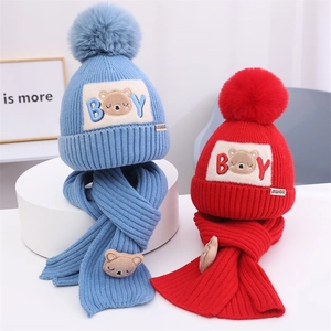 Detail von Kinder-Winterstrickmütze und Schal-Set mit Bären-Patches und Kunstpelz-Bommeln