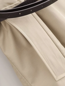 Dettaglio del trench kaki con cuciture della tasca e cintura in pelle marrone pregiata