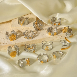 Detailed macro view of mixed gold and silver stainless steel rings with celestial patterns