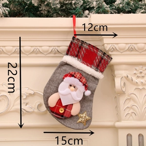 Détail de chaussette de Noël en lin gris avec Père Noël à carreaux et étoile dorée