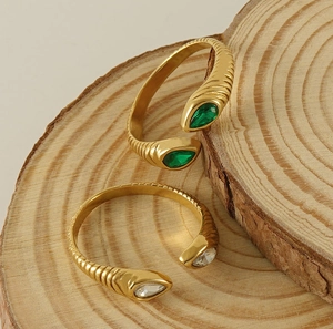 Detail of 18K gold-plated vintage rings with green teardrop zircon and spiral texture