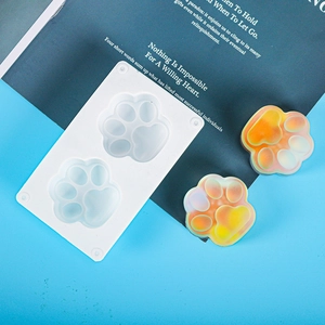 Macro view of cat paw silicone molds with colorful gradient resin crafts on a blue base