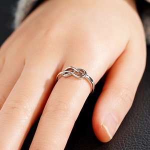 Macro-opname van zilveren oneindigheidsring met gepolijste metalen details om de vinger