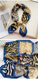 Détail d'un foulard carré en soie aux imprimés animaliers léopard et zèbre bleu et doré
