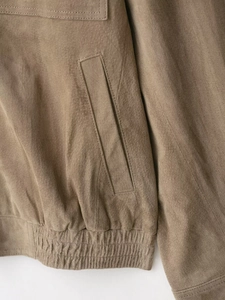 Détails des poches latérales et de l'ourlet côtelé sur veste en daim marron