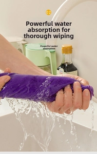 Macro di mani che strizzano un panno in microfibra viola sotto il rubinetto con spruzzi