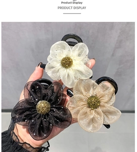 Detailed view of mesh rhinestone flower hair claws in black, cream, and gold colors