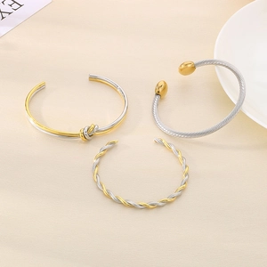 Close-up of knot design and mixed metal twisted textures on 18K gold plated bangles