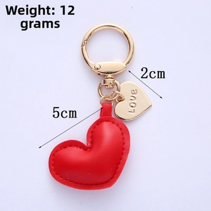 Detailed view of red quilted heart keychain with gold Love charm and 5cm size scale