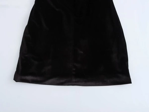 Detalle del dobladillo del vestido de terciopelo negro mostrando la textura y costuras