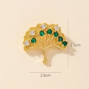Detail shot of a 2.3x2.6cm gold tree brooch with green and white round zircon stones