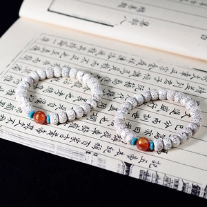 Macro shot of Xingyue Bodhi seed bracelets with red agate beads and turquoise spacers