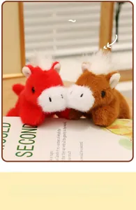 Close-up of red and brown plush pony magnets in a soft cuddle pose on a wooden desk
