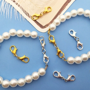 Detail of double-ended lobster clasps in gold and silver finish for DIY pearl jewelry
