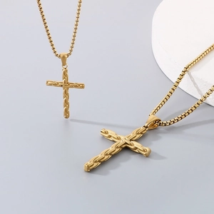 Macro detail of golden cross pendant featuring an intricate woven texture on a metal chain
