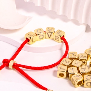 DIY gold-plated alphabet charm beads on red rope bracelet featuring LOVE square pendants