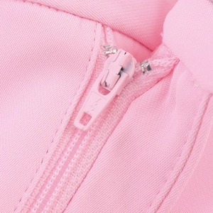 Vue macro de la fermeture éclair rose assortie et de la texture du tissu en maille