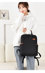 Close-up of black commuter backpack with brown leather accents and nylon texture detail