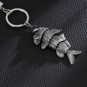 Close-up of flexible stainless steel koi fish keychain with multi-jointed body on leather