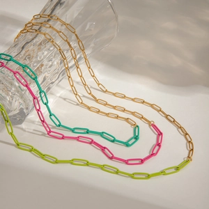 Detail of colorful paperclip link necklaces in gold, pink, teal and lime green enamel
