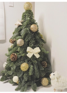 Mini DIY Christmas tree with LED lights, pine cones, gold balls, and a plush lamb toy