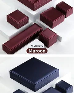 Deep maroon and navy blue brushed PU jewelry boxes displayed on white geometric blocks