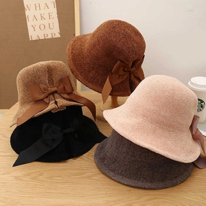 Detail of woven bucket hats in four colors with elegant silk bow ties on the back