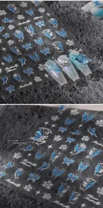Detail of laser butterfly and silver flower nail decals on matte stone background