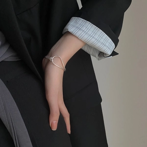 Close-up of minimalist S925 sterling silver knotted bracelet on a woman wrist