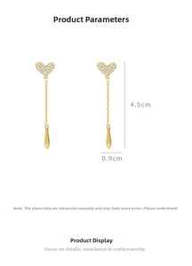 Detail shot of heart-shaped tassel earrings with pavé crystals and gold plating