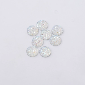 Detailed shot of 12mm round white resin gems with rainbow glitter and druzy texture