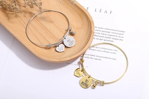 Détail du bracelet ajustable avec breloques cœur Love, disque mi mama et clochette