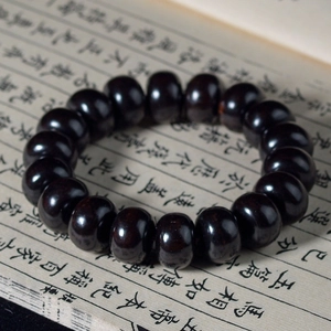 Bracelet de perles bouddhistes en bois de santal vert sur un livre de calligraphie