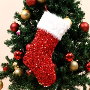 Dettaglio della calza di Natale con paillettes rosse appesa all'albero addobbato