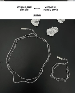 Detail of double-layer titanium steel chain necklace with minimalist metal tag and silver finish