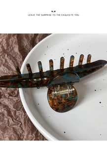Dettaglio di una grande molletta per capelli in acetato marmorizzato in una ciotola