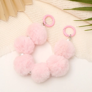 Close-up of pink faux fur ball strap with pearl accent and pink plastic ring clasp