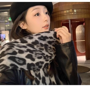 Close-up detail of leopard print scarf texture paired with a winter fashion outfit