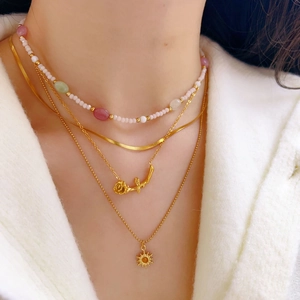 Layered gold necklace set with natural stones, pearl beads and rose sun pendants