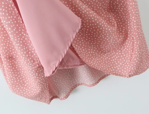 Close-up of pink polka dot lace dress hem showing smooth lining and fabric texture