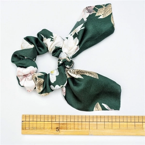 Floral dark green satin scrunchie with bowknot detail and silky texture