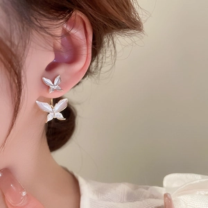 Detailed side view of elegant double butterfly stud earrings in gold and pearl white finish