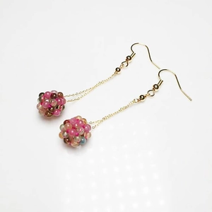 Close-up of handmade woven crystal bead ball earrings with 14K gold plated long chains