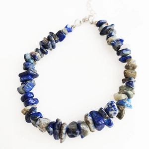 Detailed macro view of irregular lapis lazuli and grey stone bracelet with adjustable clasp