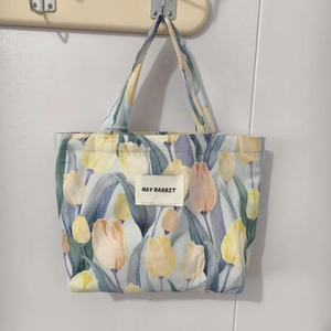 Detailed view of tulip print canvas tote bag with May Rabbit label on white background