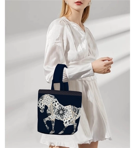 Detail of navy blue canvas tote bag featuring golden geometric horse print and straps
