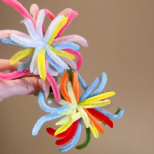 Close-up of colorful plush firework hair clip showing soft fuzzy texture and vibrant colors