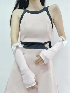 Detailed view of pink knitted arm sleeves featuring a white bow and pink heart charm